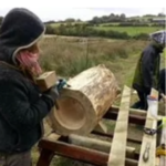 Woman carving a log into a log hive