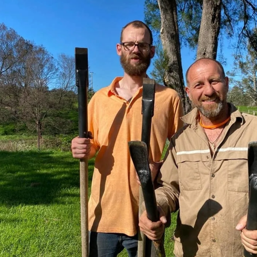 two people holding carving tools posing for a picture